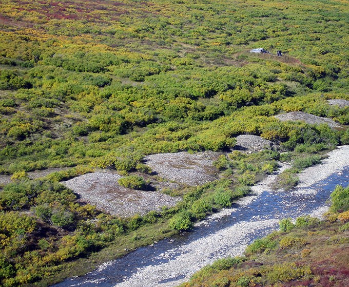 An aerial view of Humbolt Creek with a wooden structure on the tundra.
